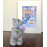 Статуетка Ведмедика Тедді з пурпурною квіткою.